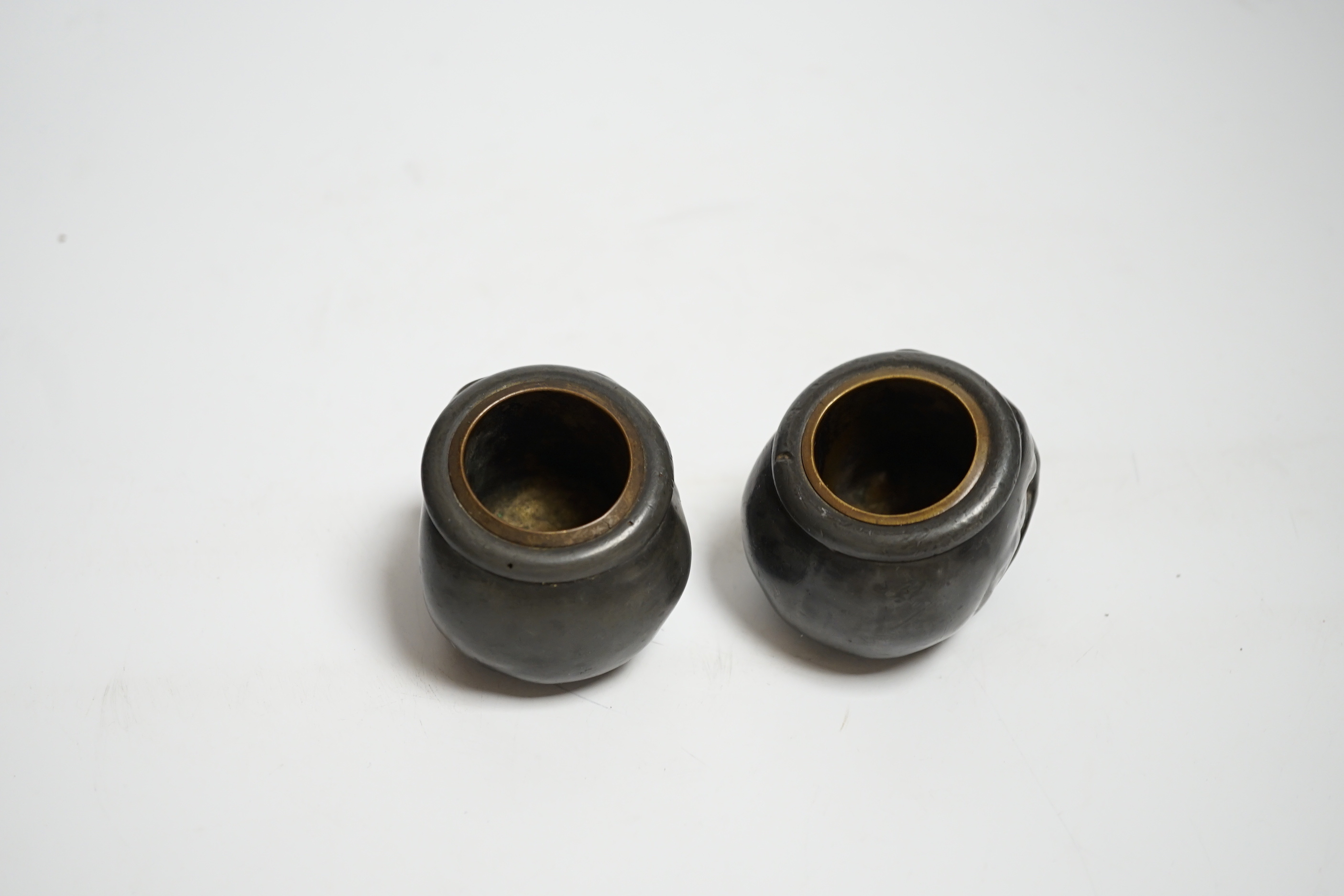 A pair of late 19th century skull shaped pewter match holders, 5cm tall